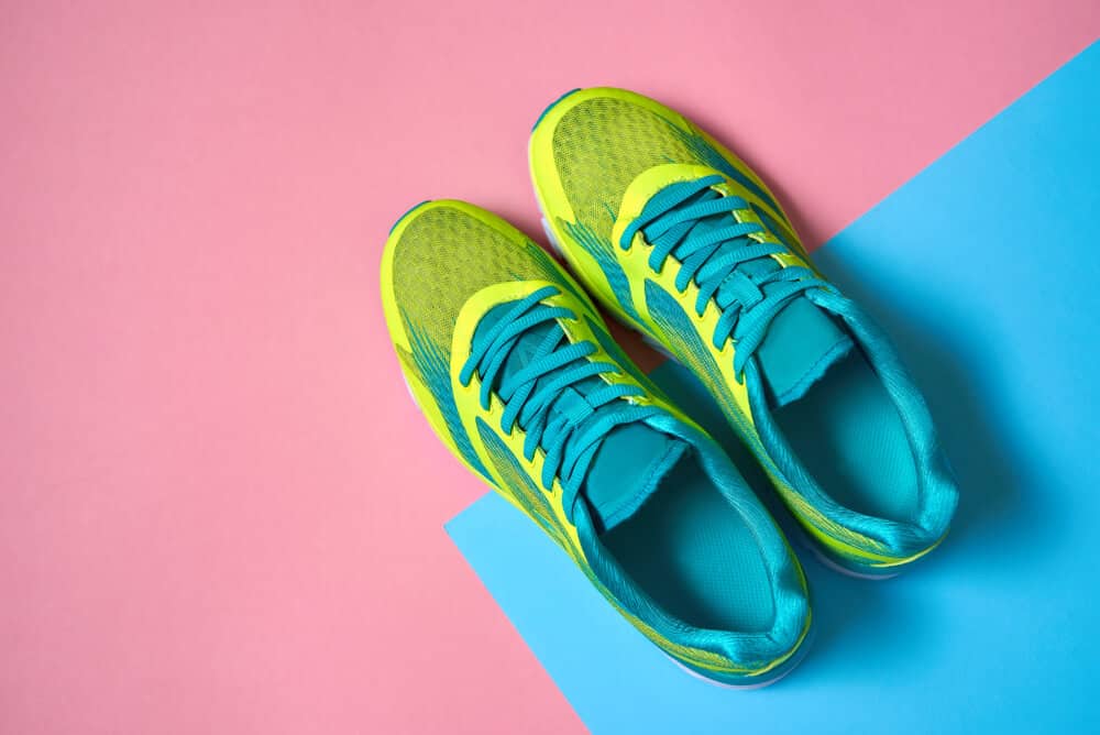 Pair of sport shoes on colorful background. New sneakers on pink and blue pastel background. Overhead shot of running shoes. Top view, flat lay